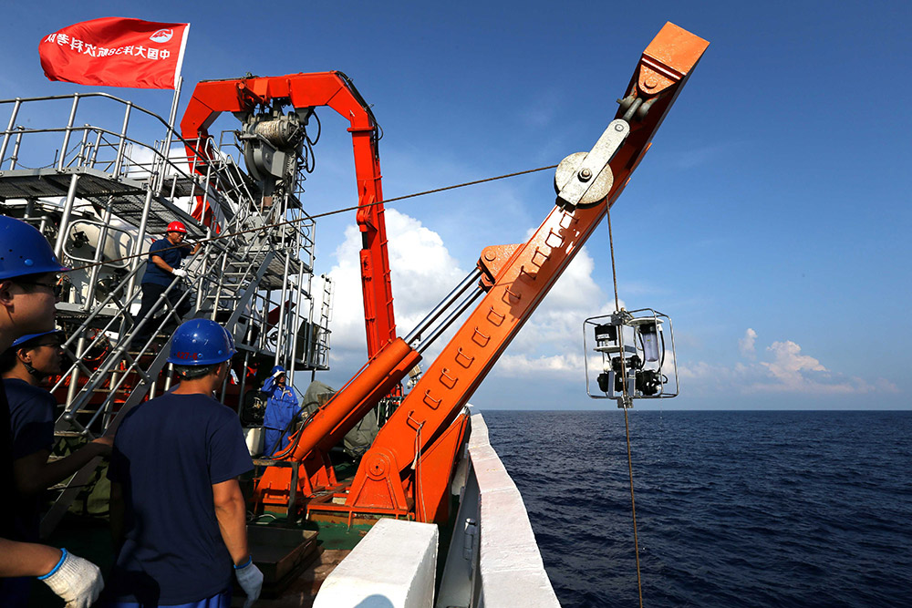 4月25日，科考队员用箱式取样器提取海底沉积物样品。