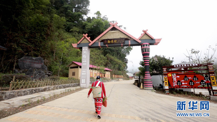 勐来村寨门的左门柱是佤族寨桩,右门柱是傣族象脚鼓.